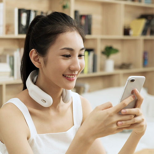 Woman using 4D Neck Massager while on her phone